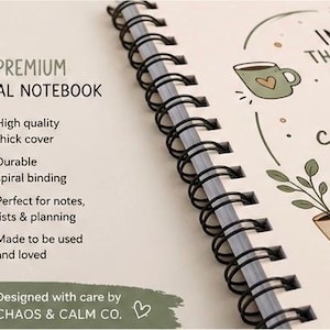 Op de afbeelding: Een spiraalnotitieboek met een cr&egrave;mekleurige kaft en zwarte draadbinding. De kaft bevat de tekst PREMIUM SPIRAL NOTEBOOK, een lijst met kenmerken en illustraties van een koffiemok en een plant in een pot. Onderaan staat de tekst DESIGNED WITH CARE BY CHAOS & CALM CO.