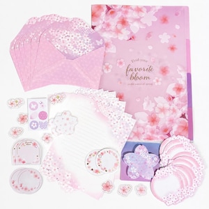 May include: A stationery set featuring pink cherry blossom motifs, including envelopes, lined writing paper, a folder with the text "Find your favorite bloom in the warm of spring," circular and flower-shaped sticky notes, and small decorative stickers.