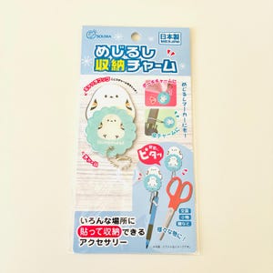 Könnte beinhalten: Eine hellblaue und weiße Verpackungskarte mit einem runden Anhänger mit gewelltem Rand und einer Shimaenaga-Vogelillustration. Der Anhänger enthält eine silberne Kugelkette. Die Verpackung zeigt japanischen Text und Anwendungsdiagramme.