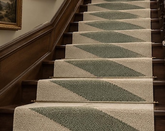 May include: A stair runner made of textured beige carpet with a repeating sage green diamond pattern. The runner is secured to wooden stairs with metallic rods at the base of each step, creating a continuous path up the staircase.