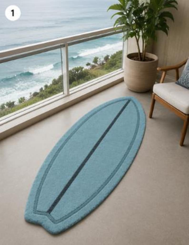 May include: A light blue rug shaped like a surfboard with a dark blue central stripe and a matching dark blue border outline. The rug has a textured, soft surface and is positioned lengthwise on a smooth floor, mimicking the form of a surfboard.