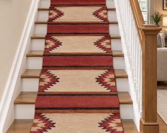May include: A long stair runner rug featuring a repeating geometric pattern in shades of red, tan, and black. The design includes jagged, sawtooth-edged shapes across a neutral tan background, separated by solid red and black horizontal stripes.
