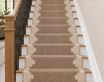 May include: A stair runner featuring a textured brown centre with a cream-coloured geometric border pattern. The runner extends down the length of the wooden staircase and is finished with a fringe detail at the bottom edge of the first step.