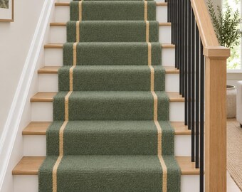 May include: A sage green stair runner with a textured weave and a vertical beige stripe running down the centre. The runner is installed over wooden stairs with white risers, featuring a black metal railing and a wooden handrail.