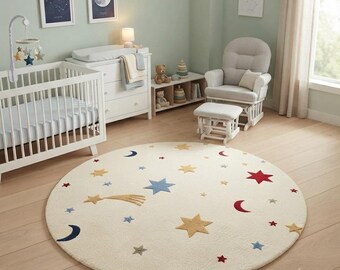 May include: A round, cream-coloured area rug featuring a celestial pattern of embroidered stars and moons in shades of red, blue, and gold. The design includes various sizes of five-pointed stars, crescent moons, and a single shooting star motif.