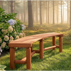 May include: A wooden bench with a curved seat and log-style legs sits on a grassy area. The bench is made of reddish-brown wood and appears sturdy. The background features a forest with tall trees and a soft, diffused light.