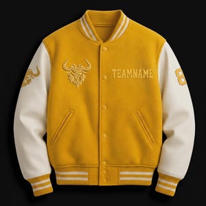May include: A yellow varsity jacket with cream-colored sleeves. The jacket features a bull logo and the word "TEAMNAME" embroidered in gold. The number "8" is on the right sleeve. Ribbed cuffs and collar have white stripes.