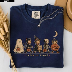 Navy t-shirt with five children in Halloween costumes trick-or-treating under a moon.