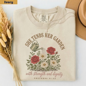 Camiseta "Ella cuida su jardín" Proverbios 31:25, Camiseta con versículo bíblico sobre jardinería, Regalo para amantes de las plantas cristianas, Fuerza y dignidad Colores cómodos