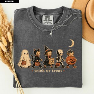 Gray t-shirt with vintage Halloween characters: ghost, cat, witch, skeleton, pumpkin.