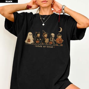 Black t-shirt with Halloween characters dressed as a ghost, cat, witch, skeleton, and pumpkin.