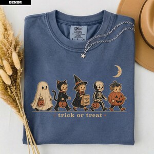 Blue t-shirt with Halloween characters and "trick or treat" text.