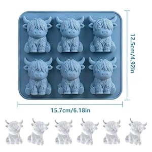 May include: A light blue silicone mold featuring six identical cavities shaped like Highland cows. The rectangular mold measures 6.18 inches in width and 4.92 inches in height. Six clear, finished Highland cow figures are displayed below the mold.
