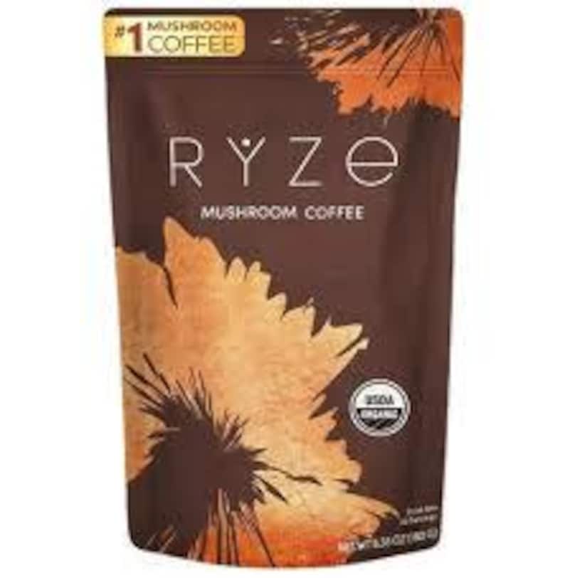 May include: A brown pouch of Ryze Mushroom Coffee with a large, stylized orange and brown leaf design. The text "RYZE MUSHROOM COFFEE" is in white, with "#1 COFFEE" in yellow. The pouch also has a USDA Organic seal.