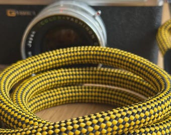 Alça de câmera artesanal em corda trançada preta e amarela para câmeras DSLR.