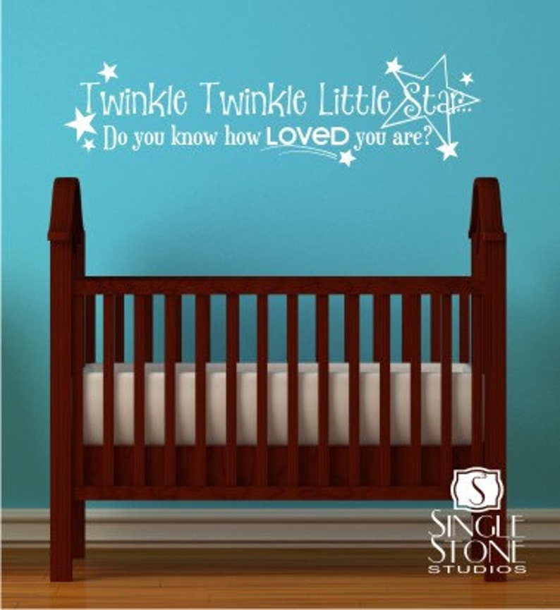 K&ouml;nnte beinhalten: Wei&szlig;er Wandaufkleber aus Vinyl mit dem Text "Twinkle Twinkle Little Star Do you know how LOVED you are?" und einem Sternendesign. Der Aufkleber befindet sich an einer blauen Wand &uuml;ber einem braunen Holzbabybett.