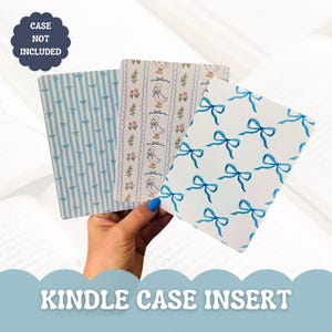 May include: Three Kindle case inserts with different patterns. One has blue bows on white, another has blue stripes with bows, and the third has ducks and floral designs. The text "CASE NOT INCLUDED" and "KINDLE CASE INSERT" are also visible.