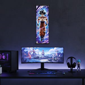 Puede incluir: Una configuración de juego con un monitor curvo grande, teclado, ratón y una torre de ordenador con iluminación púrpura. Un rollo de pared de Dragon Ball Z cuelga sobre el monitor. Una figura y auriculares también están en el escritorio.