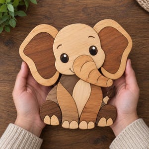 Könnte beinhalten: Ein Elefanten-Holzpuzzle mit verschiedenen natürlichen Holzmaserungen. Der Elefant hat große Ohren, einen geschwungenen Rüssel und dunkle, eingelegte Augen. Das Puzzle besteht aus mehreren ineinandergreifenden Teilen in hellen und dunklen Brauntönen.