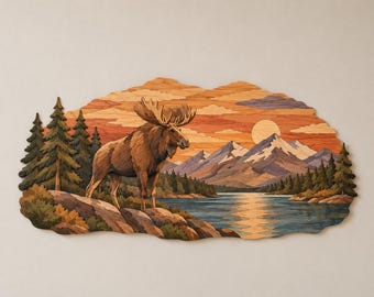 Op de afbeelding: Een meerlaags houten wanddecoratie met een eland die op een rotsachtige oever bij een meer staat. De scène bevat groenblijvende bomen, besneeuwde bergen en een zonsonderganglucht met een ronde zon, allemaal gemaakt van diverse houttinten.