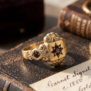 Anillo de sello victoriano con granate, engaste de estrella en oro vermeil de 14k, banda grabada, joyería artesanal de herencia.