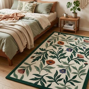 May include: A rectangular area rug featuring a cream-colored background with a repeating botanical pattern of dark green leaves and stylized flowers in shades of orange, rust, and blue, finished with a solid dark green border trim.