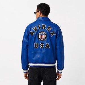 May include: A vibrant blue leather jacket with the word "AVIREX" arched across the back, above a circular patch with the words "All Americans" and "USA". The jacket has a ribbed hem and cuffs with white stripes.