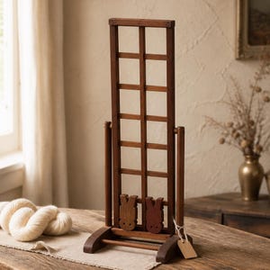 May include: A tall, rectangular wooden lattice frame with a dark brown finish, featuring a grid pattern. Two small, carved wooden rabbit-shaped figures are attached to the lower section of the frame. A small, blank, light-colored paper tag hangs from the side.