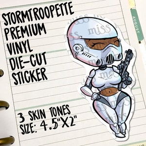 May include: A die-cut vinyl sticker featuring a cartoon Stormtrooper character with brown skin, holding a blaster. The sticker is white and gray, with the text "STORMTROOPETTE PREMIUM VINYL DIE-CUT STICKER" and "3 SKIN TONES SIZE: 4.5"X2"" in black.