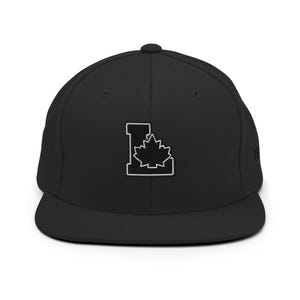 Pode incluir: Um boné de beisebol preto com aba reta e copa estruturada. A parte frontal apresenta uma letra L branca bordada com uma silhueta de folha de bordo branca centralizada. O boné possui um botão no topo e ilhós costurados para ventilação.