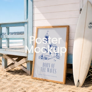 May include: A rectangular wooden frame containing a white poster with a blue illustration of a lighthouse and the text "BORN OF THE WAVES" and "Modern Coastal Poster Collection" printed in blue, positioned next to a white surfboard.