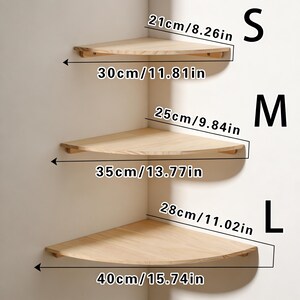 Pu&ograve; includere: Tre mensole angolari in legno di diverse dimensioni sono esposte contro un muro bianco. La mensola pi&ugrave; piccola &egrave; larga 30 cm, quella media 35 cm e quella pi&ugrave; grande 40 cm. Ogni mensola &egrave; etichettata con una taglia: S, M e L.