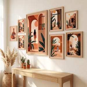 Peut inclure: Un ensemble de sept cadres muraux présentant des illustrations aux tons terre cuite, beige et vert foncé représentant des silhouettes, des arches et des plantes. Les cadres en bois clair sont disposés sur un mur au-dessus d'une console en bois.
