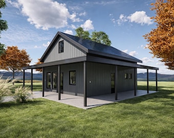 May include: A modern, dark gray house with a porch and black trim. The house has a gabled roof and is surrounded by green grass, trees, and a blue sky with clouds. The house is in a rural setting.
