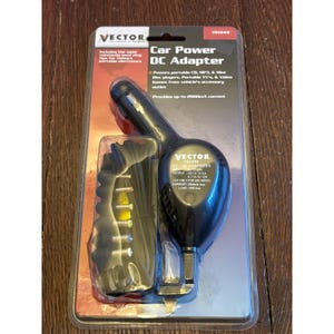 May include: A Vector brand Car Power DC Adapter in original blister packaging. The black adapter features a cigarette lighter plug and a coiled cord with multiple colored interchangeable tips. The packaging displays technical specifications.