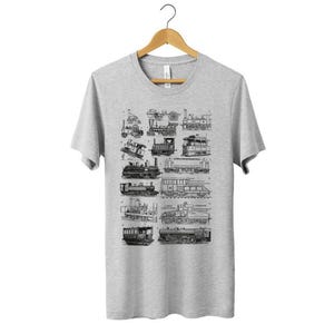 May include: A heather grey short-sleeved t-shirt featuring a black and white graphic print of various vintage steam locomotives and train engines arranged in a grid pattern on the front, displayed on a wooden hanger.