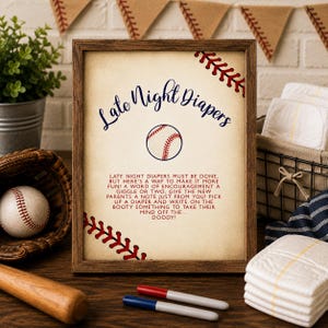 May include: A framed sign with a beige background featuring the text Late Night Diapers, a baseball graphic, and a poem about writing on diapers. The sign is decorated with red baseball stitching patterns in the corners and has a dark wood frame.