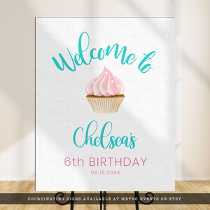 May include: A white sign with the words "Welcome to" in teal script above a pink cupcake with white polka dots. Below the cupcake, the sign reads "Chelsea's 6th BIRTHDAY" with the date 06.19.20XX.