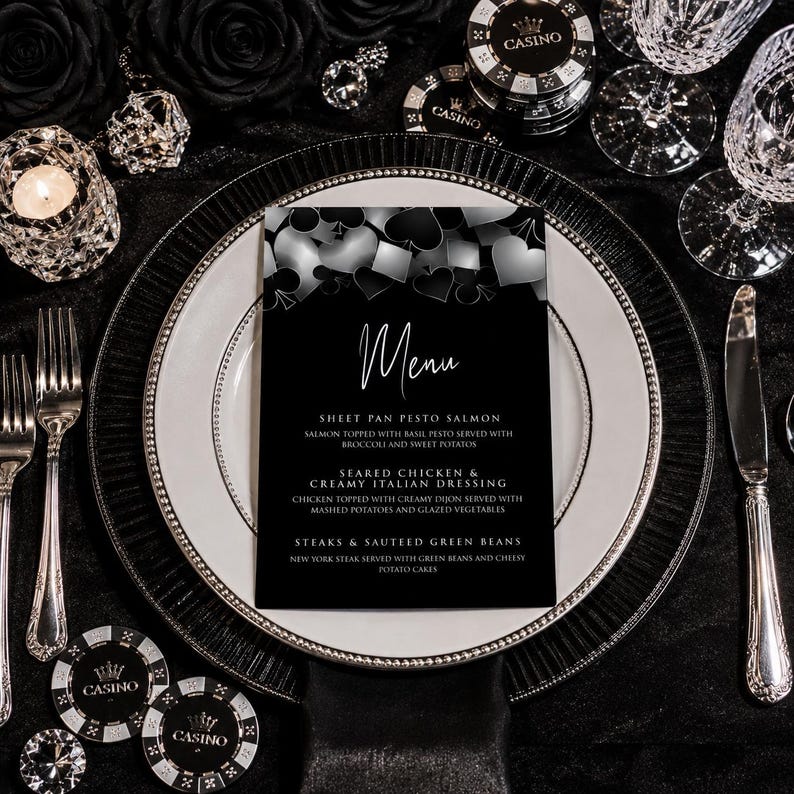May include: A black and white menu card featuring a top border of playing card suit symbols including hearts, diamonds, clubs, and spades. The text reads Menu, Sheet Pan Pesto Salmon, Seared Chicken & Creamy Italian Dressing, and Steaks & Sauteed Green Beans.