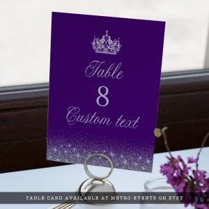 A glam style sweet sixteen and quinceanera table number. This glittery design is created with faux silver glitter on a purple background and a princess crown. Designed by MetroEvents.