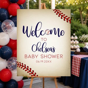 Może przedstawiać: Witamy znak na baby shower o tematyce baseballowej na drewnianym sztaludze. Znak głosi "Witamy na baby shower Chelsea" z grafiką baseballową i datą. Czerwone, białe i niebieskie balony w tle.