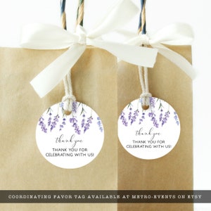 May include: Two brown paper gift bags with white ribbon bows. Each bag has a round tag with a lavender floral design and the words "thank you" and "THANK YOU FOR CELEBRATING WITH US!"