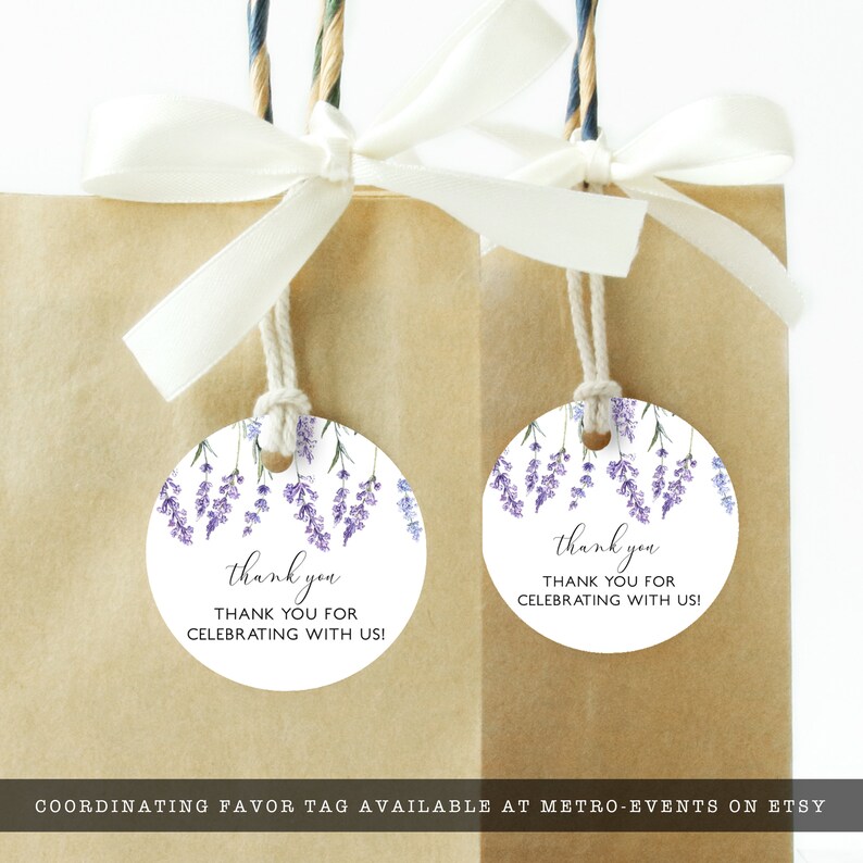 May include: Two brown paper gift bags with white ribbon bows. Each bag has a round tag with a lavender floral design and the words "thank you" and "THANK YOU FOR CELEBRATING WITH US!"