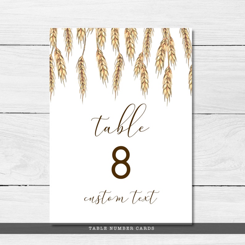 May include: White table number card with a brown wheat border. The card says "table 8 custom text" and "TABLE NUMBER CARDS" at the bottom.