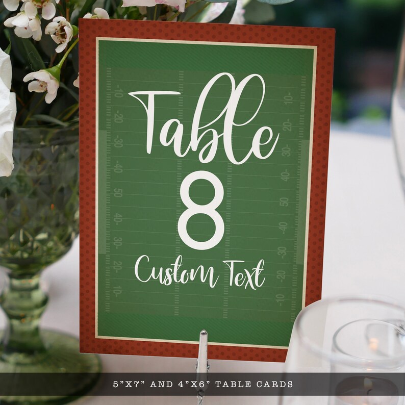 May include: A rectangular table card featuring a green football field graphic with white yard line markings. The text reads Table 8 and Custom Text in white script and sans-serif fonts. The card has a dark red border with a subtle polka dot pattern.