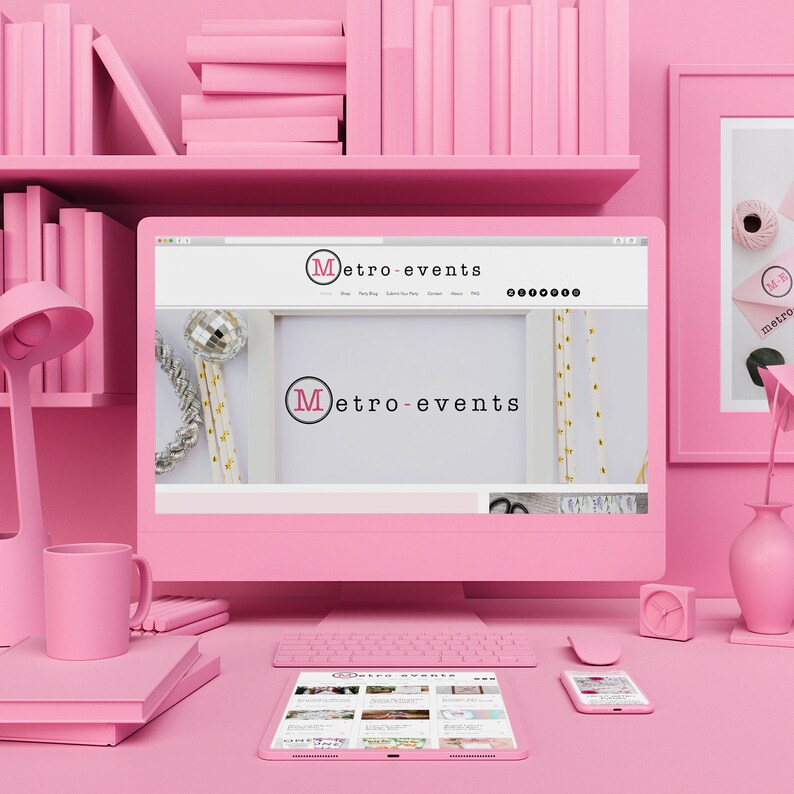 May include: A pink computer setup with a monitor displaying the "Metro-Events" website. The desk includes a keyboard, mouse, tablet, and smartphone. A pink lamp, mug, and books are also visible, along with a shelf of pink books.