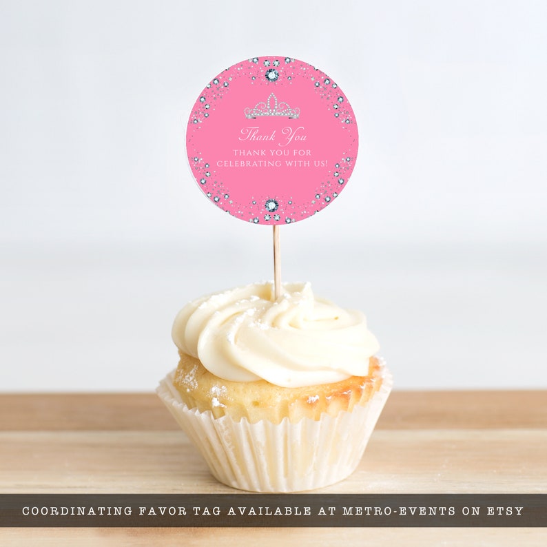 May include: Pink cupcake topper with a white frosting swirl and a round pink and silver glitter sticker with a crown and the text "Thank You THANK YOU FOR CELEBRATING WITH US!"