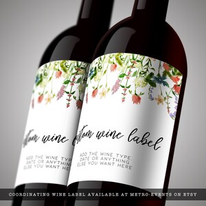 Pode incluir: Duas garrafas de vinho com r&oacute;tulos personalizados. Os r&oacute;tulos apresentam um design floral em aquarela com fundo branco. O texto no r&oacute;tulo diz "Custom wine label" e inclui espa&ccedil;o para adicionar o tipo de vinho, a data ou qualquer outra coisa. Os r&oacute;tulos s&atilde;o decorados com flores coloridas.