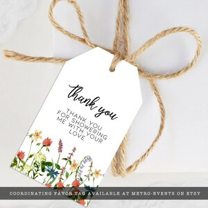 Pode incluir: Etiqueta de presente branca com um design floral em aquarela e as palavras "Thank you". A etiqueta &eacute; amarrada com barbante. O texto na etiqueta diz: "Thank you for showering me with your love."