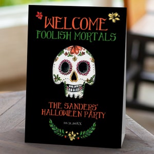 Day of the dead themed welcome sign a watercolor-style sugar skull with flower and leaf accents on a black background. Designed By MetroEvents